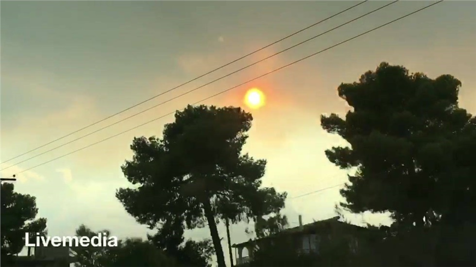 Ο ήλιος πνιγμένος στο σύννεφο καπνού από τη φωτιά στους Αγίους...