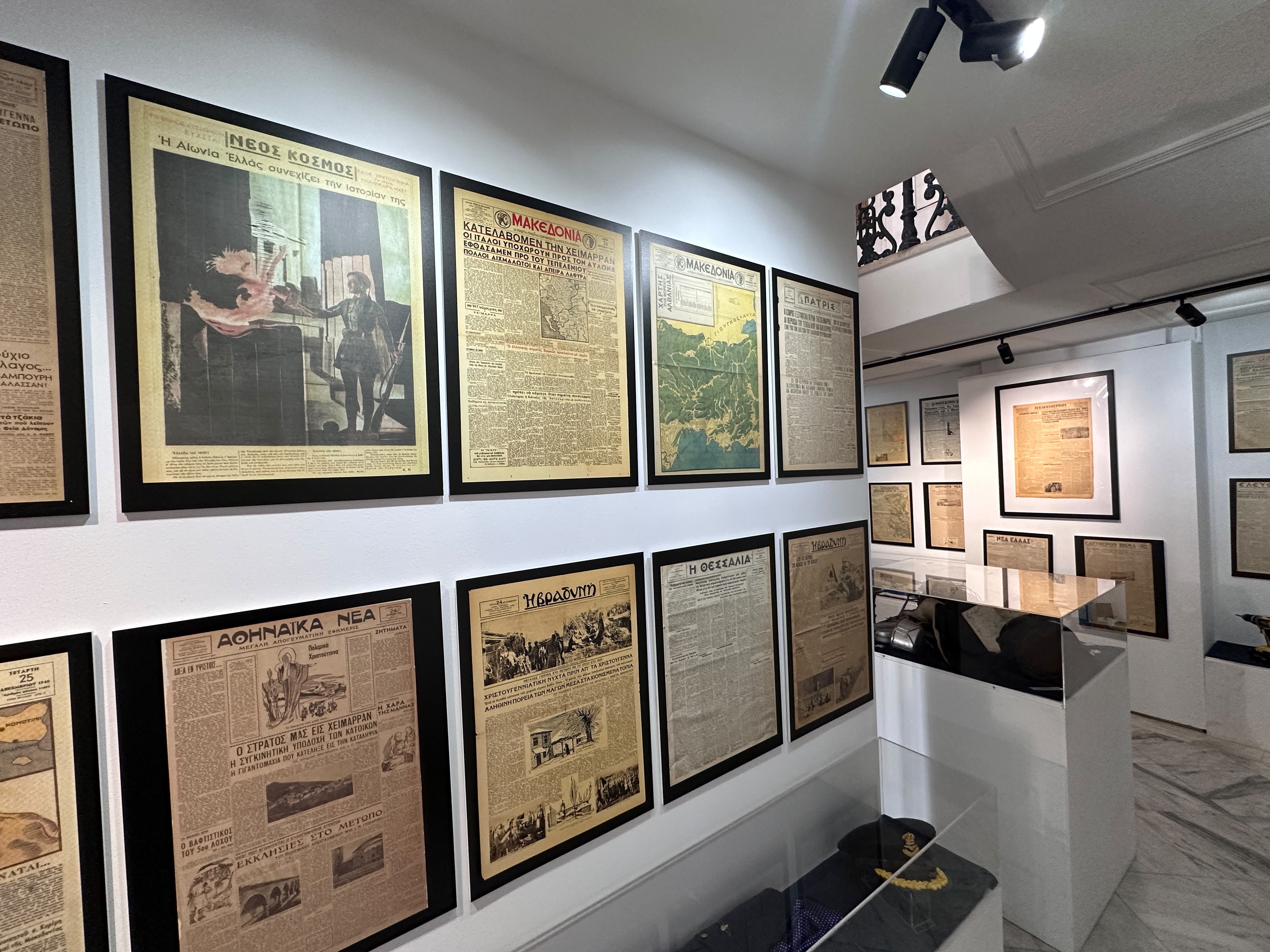 Πρωτοσέλιδα εφημερίδων του 1940 σε κορνίζες στους τοίχους της έκθεσης